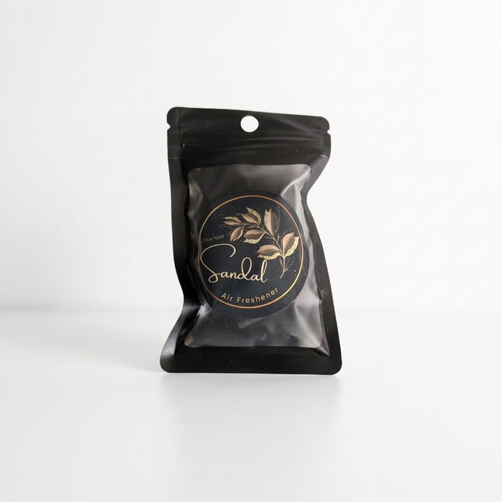A black resealable stand-up pouch with a hanging hole filled with black incense cones and a circular gold logo reading &