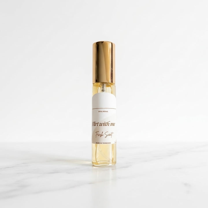 A small clear glass roll-on bottle with a metallic gold cap and a white label reading &