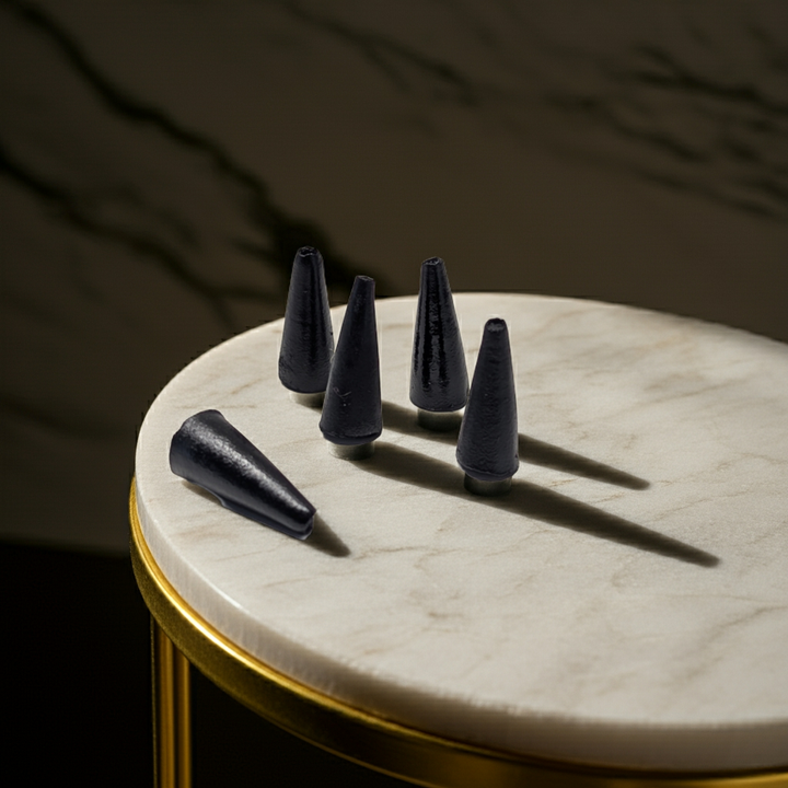 Black cone-shaped objects on a marble surface with a dark background