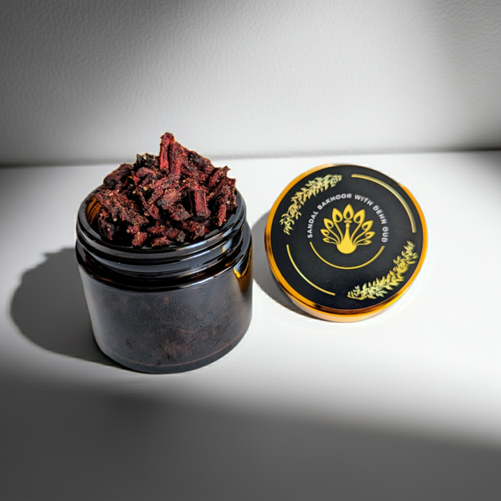 Black container with dried herbs on a white surface
