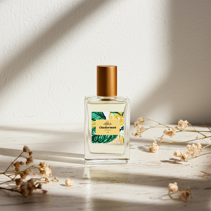 Perfume bottle with gold cap on a light surface with dried flowers