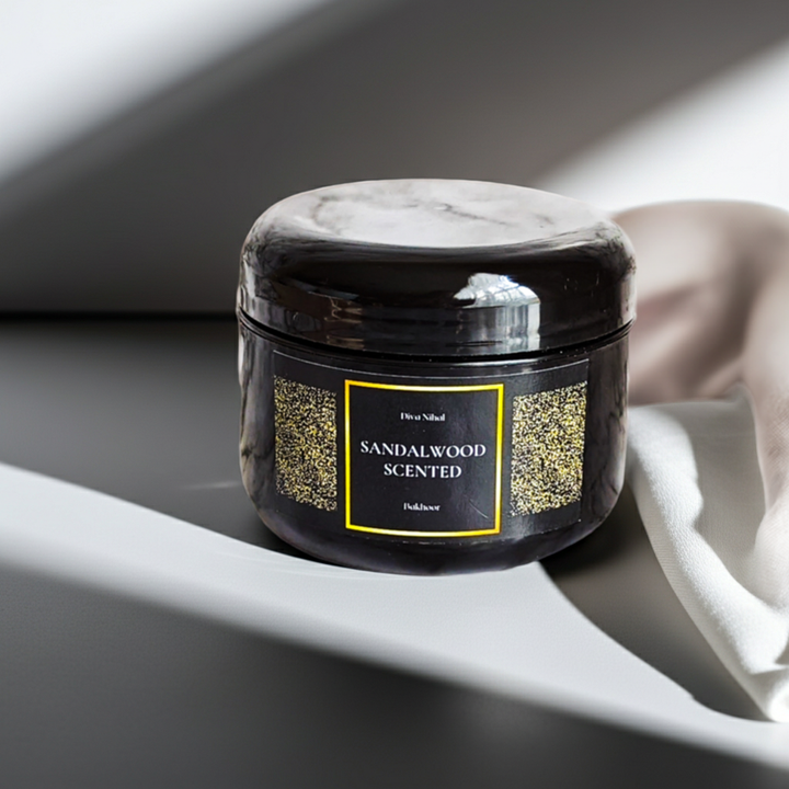 Sandalwood scented jar on a gray surface with a white towel