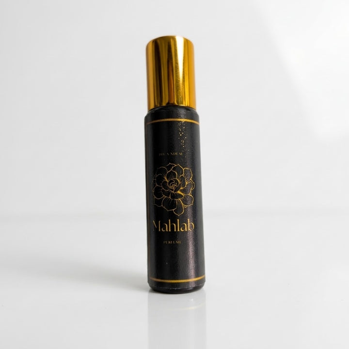 A black cylindrical perfume bottle with a shiny gold cap, featuring a gold floral design and the brand name &