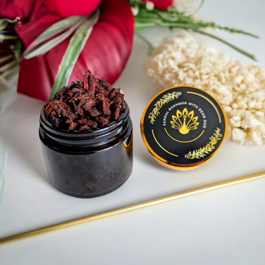 A jar of Sudanese Sandalwood Bakhoor incense with a black lid, placed on a white surface, with decorative elements in the background.