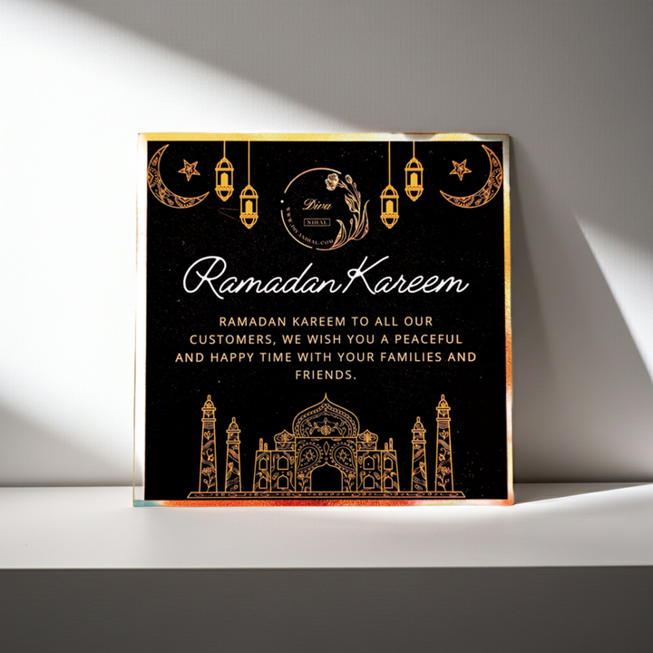 A square black Ramadan greeting card or plaque with elegant gold foil-style illustrations and text reading &